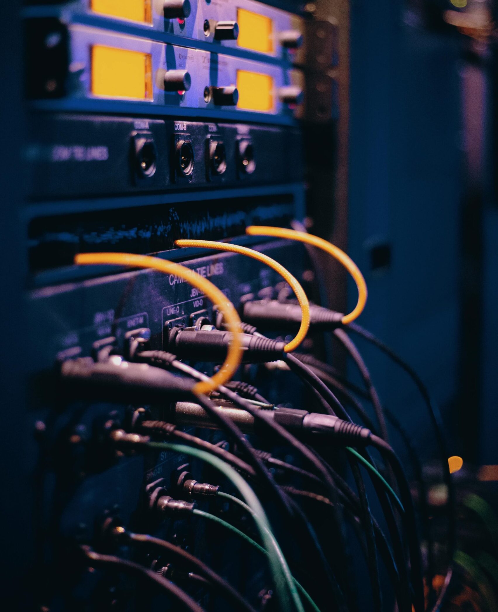 Close-up of network cables and ports in a server rack, showcasing connectivity.
